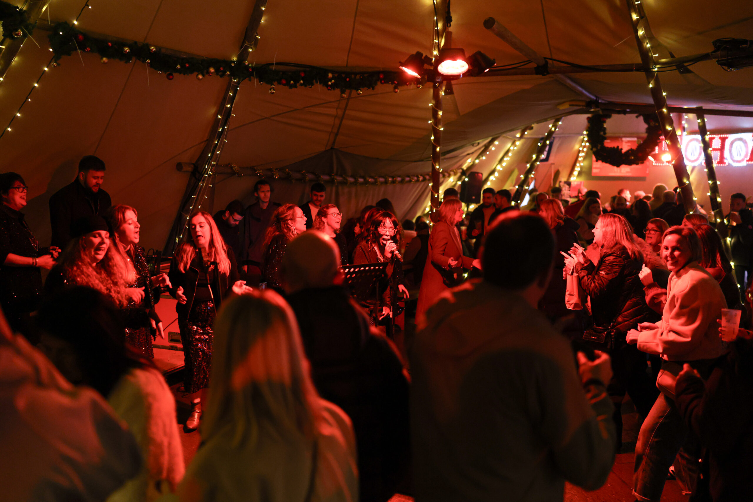 The Motown Gospel Choir performing live inside the Christmas Town Tipis, surrounded by the audience
